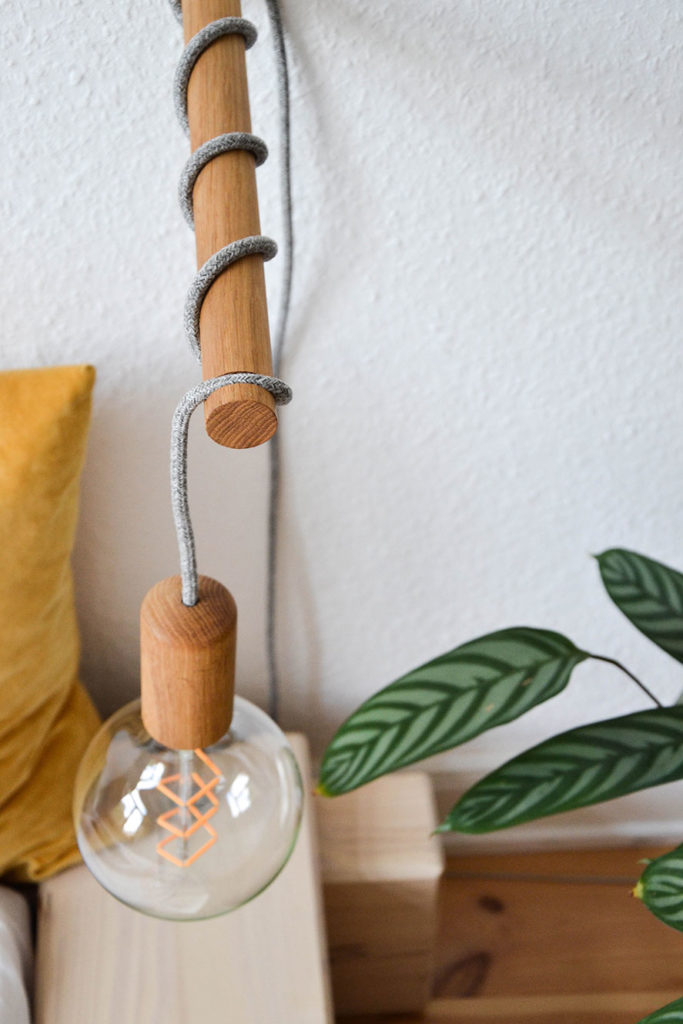 Holzlampen mit Seilschlaufe auf Tisch
