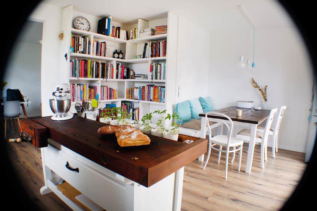 Küchen- und Backbücher auf einem holzgetäfelten Regal in minimalistischem Wohnraum