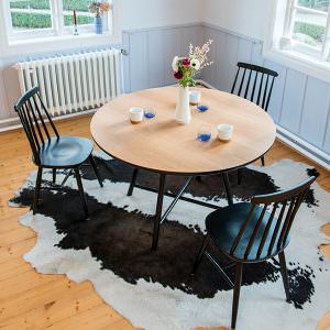 Tisch mit Cowhide-Rug und Dekoration in designerem Raum