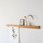 Minimalistisches Wandregal mit Dekoration und botanischem Kunstblatt in skandinavischer Stilrichtung