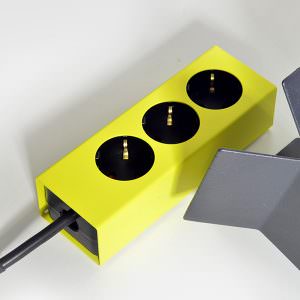 Mehrfachstecker mit grellem Design auf weißem Tisch
