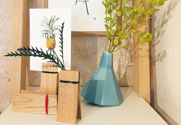 Wood table with blue vase, potted plant and pineapple in a cozy room