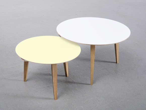 Zwei moderne runde Couchtische mit minimalistischem Design auf schlanken Holzbeinen vor einem hellgrauen Hintergrund