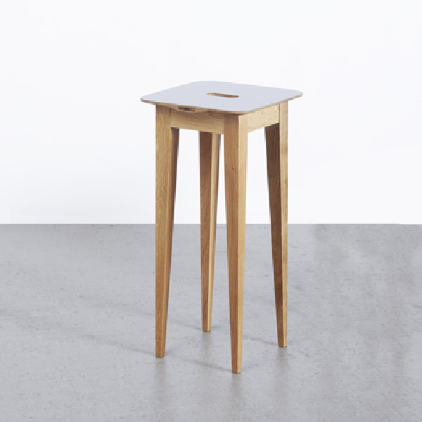 Holztisch mit weißen Oberflächen und beiden Stühlen auf betoniertem Boden