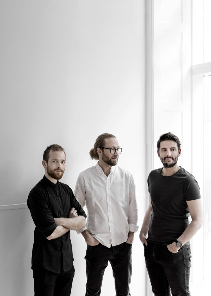 Drei Männer im weißen Raum des Hamburger Designladens posing für eine Fotografie von Chris Tonnesen