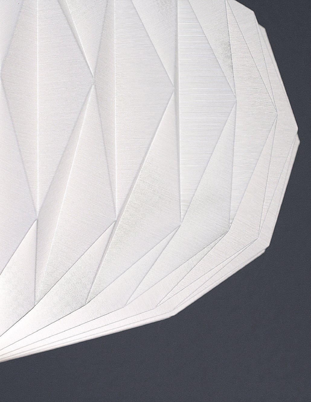 Elegante Wandleuchte oder Deckenleuchte mit origamiähnlichem Schirm in weissem Textil auf dunkelgrauer Hintergrund