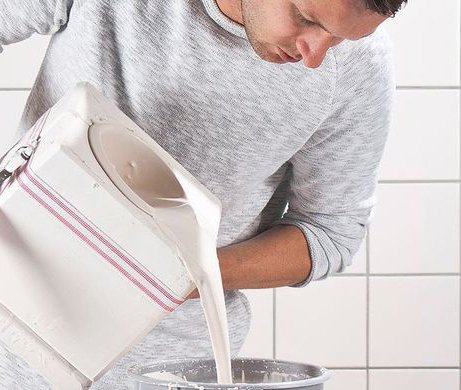Moderner Mülleimer aus weißem Kunststoff mit rosa Akzentstreifen in hellem Badezimmer