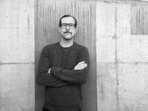 Klassischer Woll-Strickpullover auf rohem Betonhintergrund in minimalistischem Setting