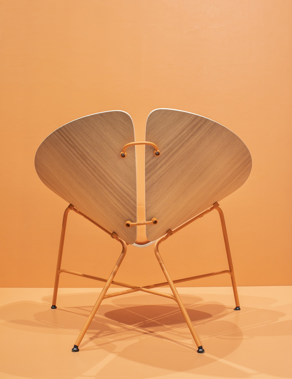 Moderner Designstuhl mit herzförmiger Rückenlehne und warmem Holzgestell von hinten