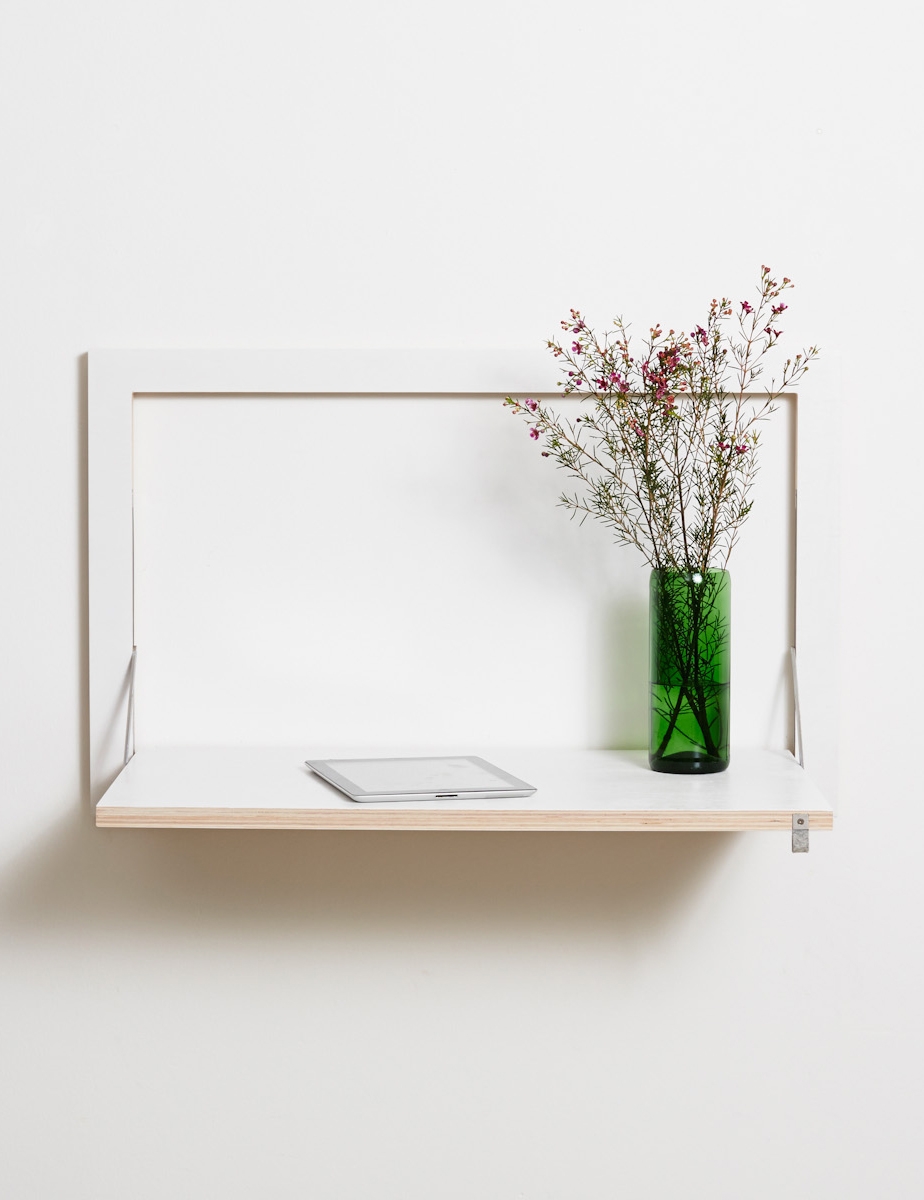 minimalistisches Wandregal mit silberner Tablettsurfe und grüner Glasvase