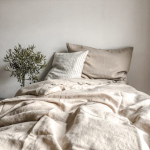 Stilvolles Schlafzimmer mit leinenen Bettwäsche in Creme und Beigefärbt