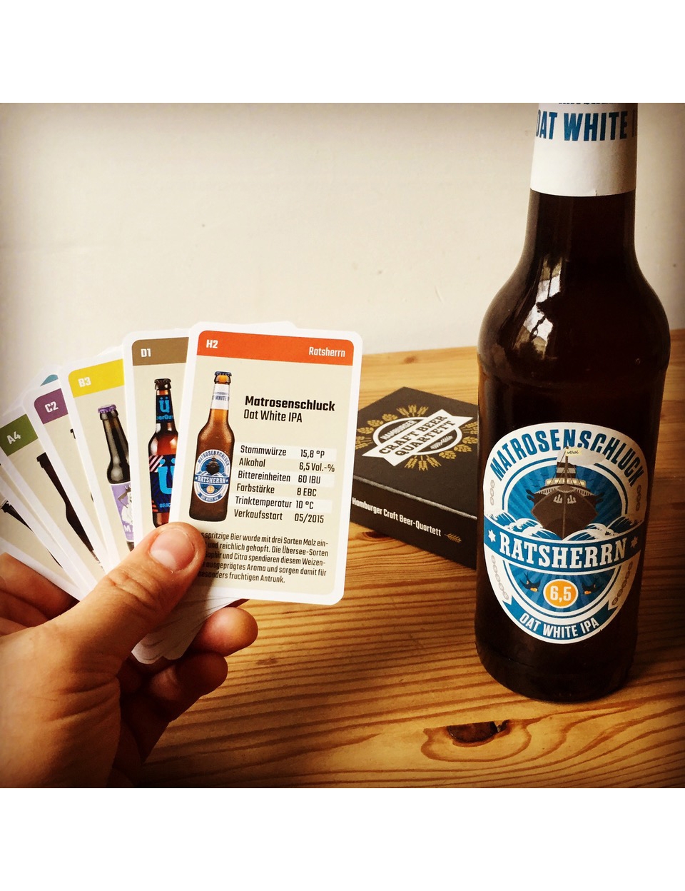 Stilvolle Bierkartenpräsentation mit Hand, Flasche und Holzverpackung auf hellen Holzoberfläche