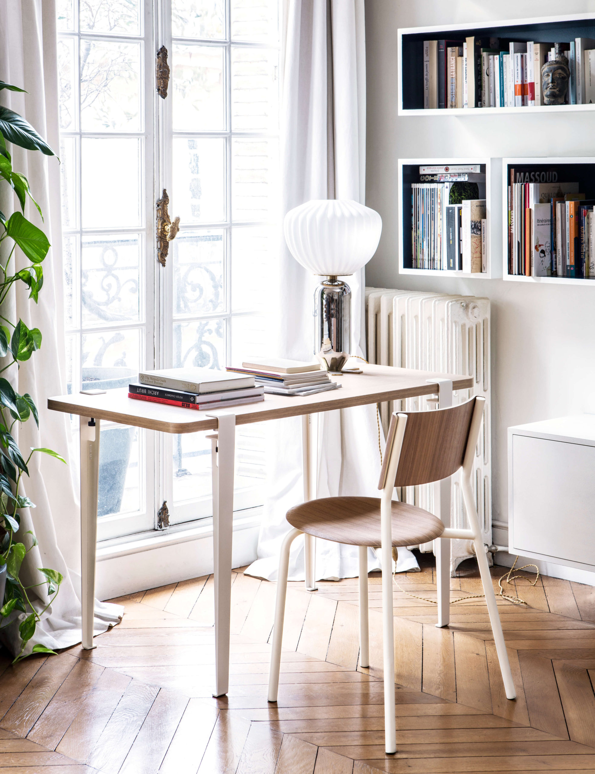 Minimalistischer Arbeitsplatz mit Holzschreibtisch und weissem Stuhl