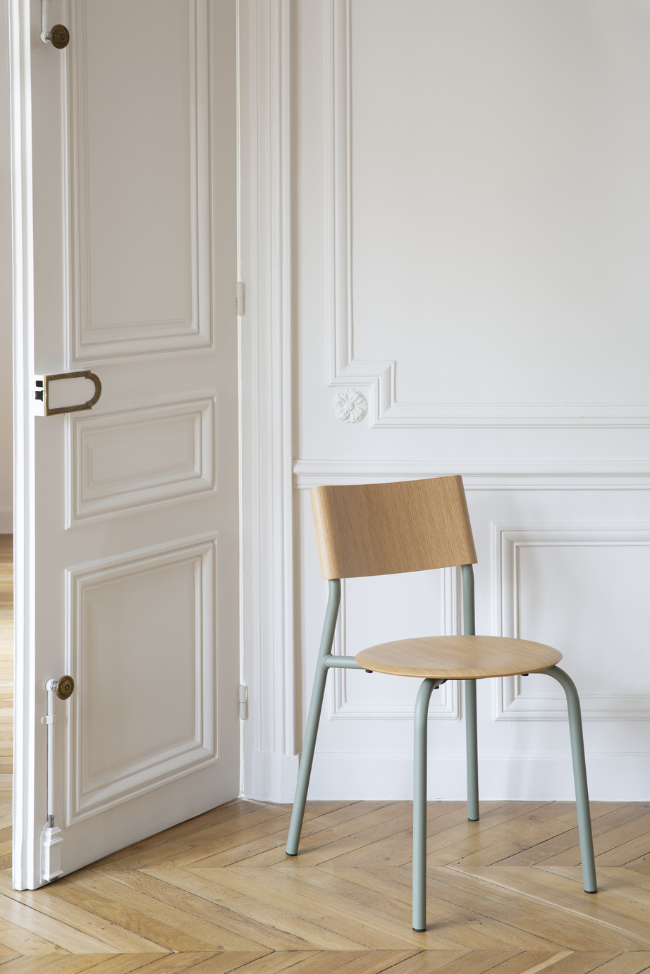 Skandinavischer Designstuhl mit heller Holzschale und mintgrünen Metallbeinen in minimalistischem Wohnraum