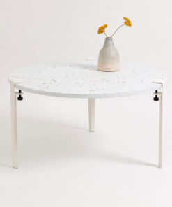 Moderner Couchtisch mit Terrazzo-Tischplatte, weißen Metallbeinen und Keramikvase auf minimalistischem Hintergrund