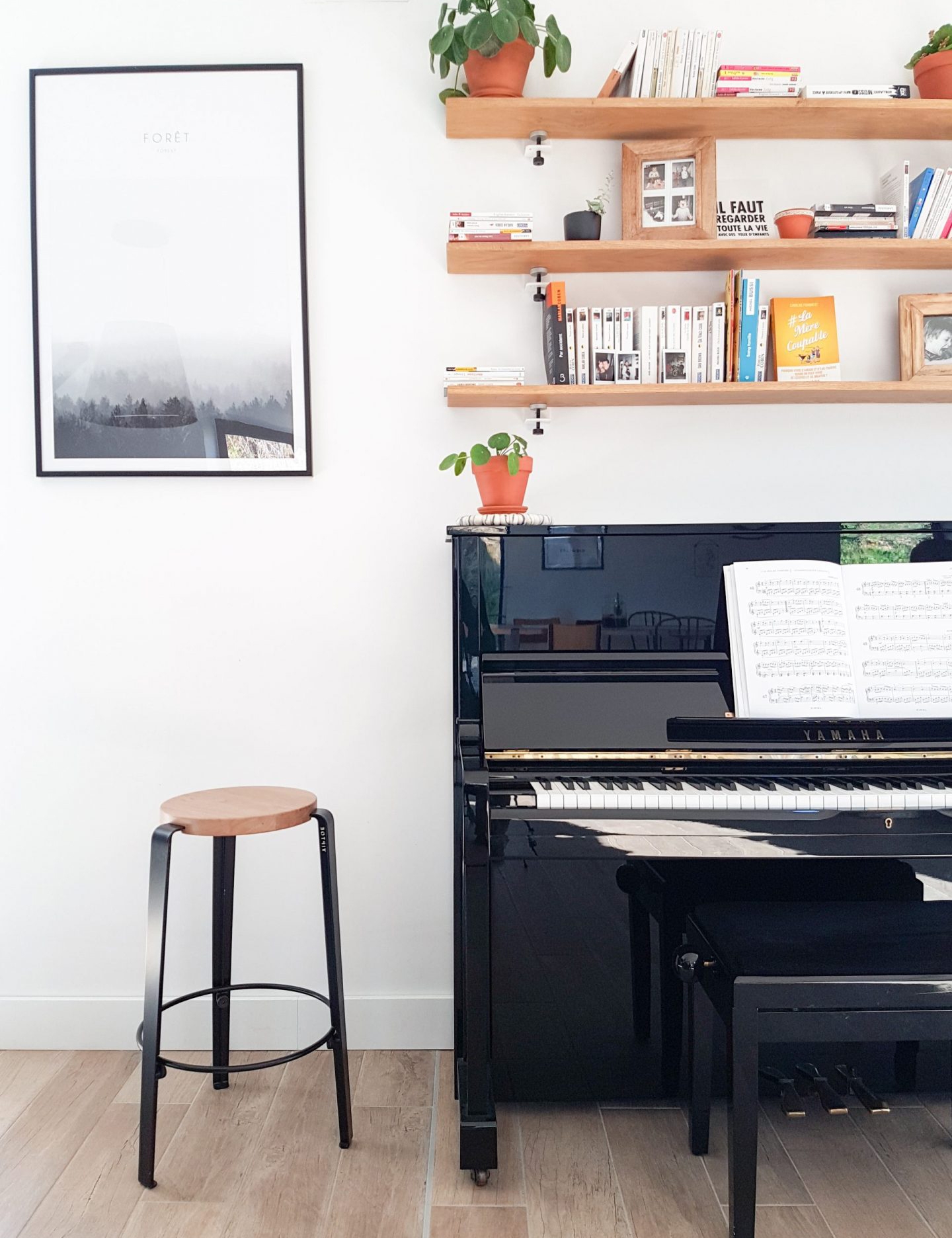 Stilvolles Musikzimmer mit schwarzem Klavier, modernem Barhocker und natürlichen Holzregalen