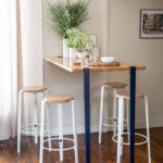 Moderne Stehtisch-Konstellation mit Barhockern und minimalistischen Accessoires