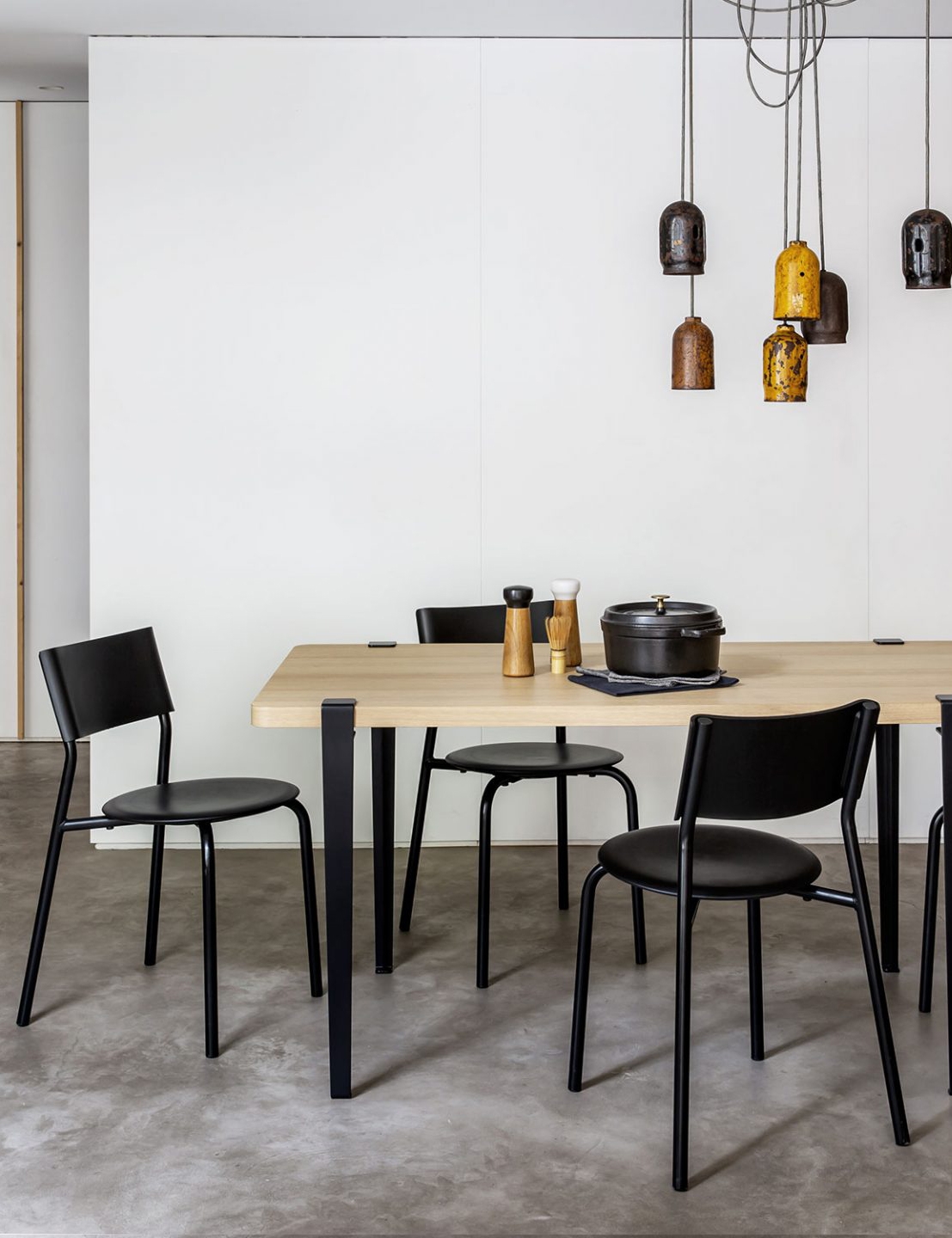 Holztisch mit schwarzen Stühlen und dekorativen Accessoires in einladendem Esszimmerambiente