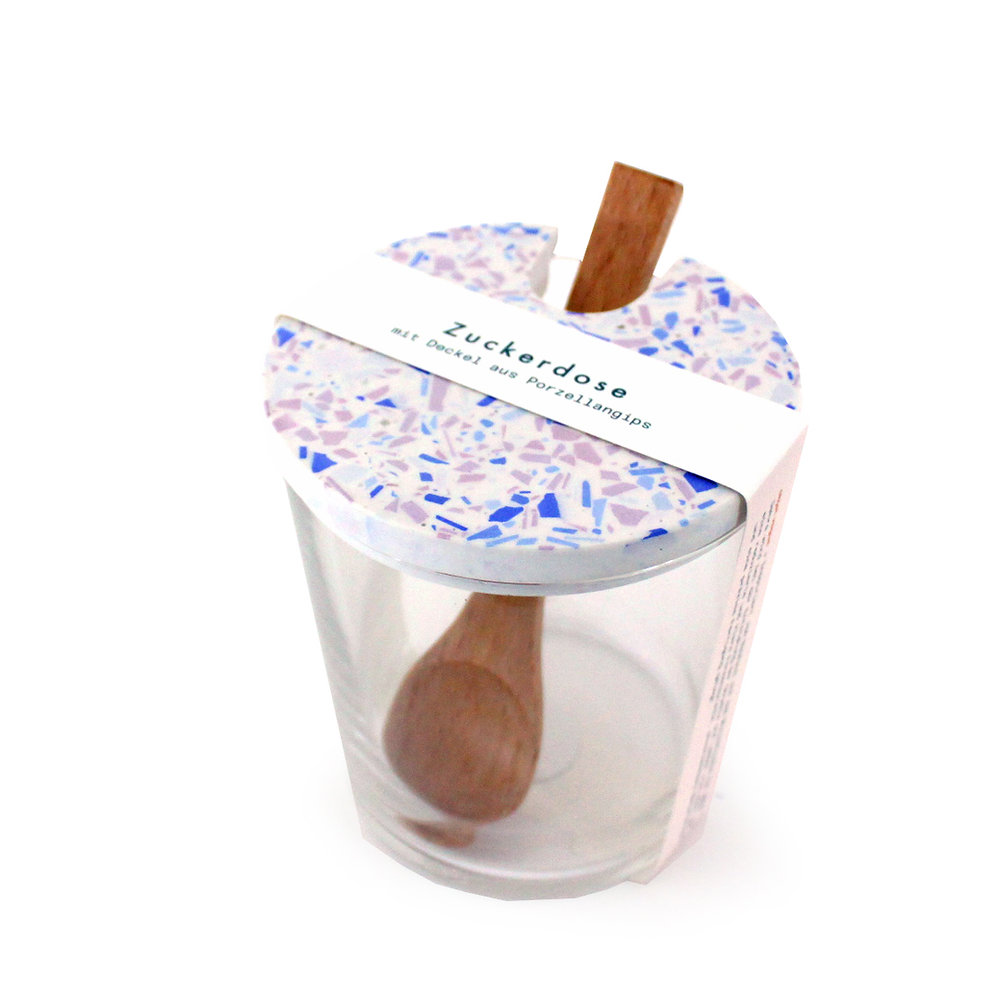 Glas mit Löffel in zuckerdosemotivierter Verpackung