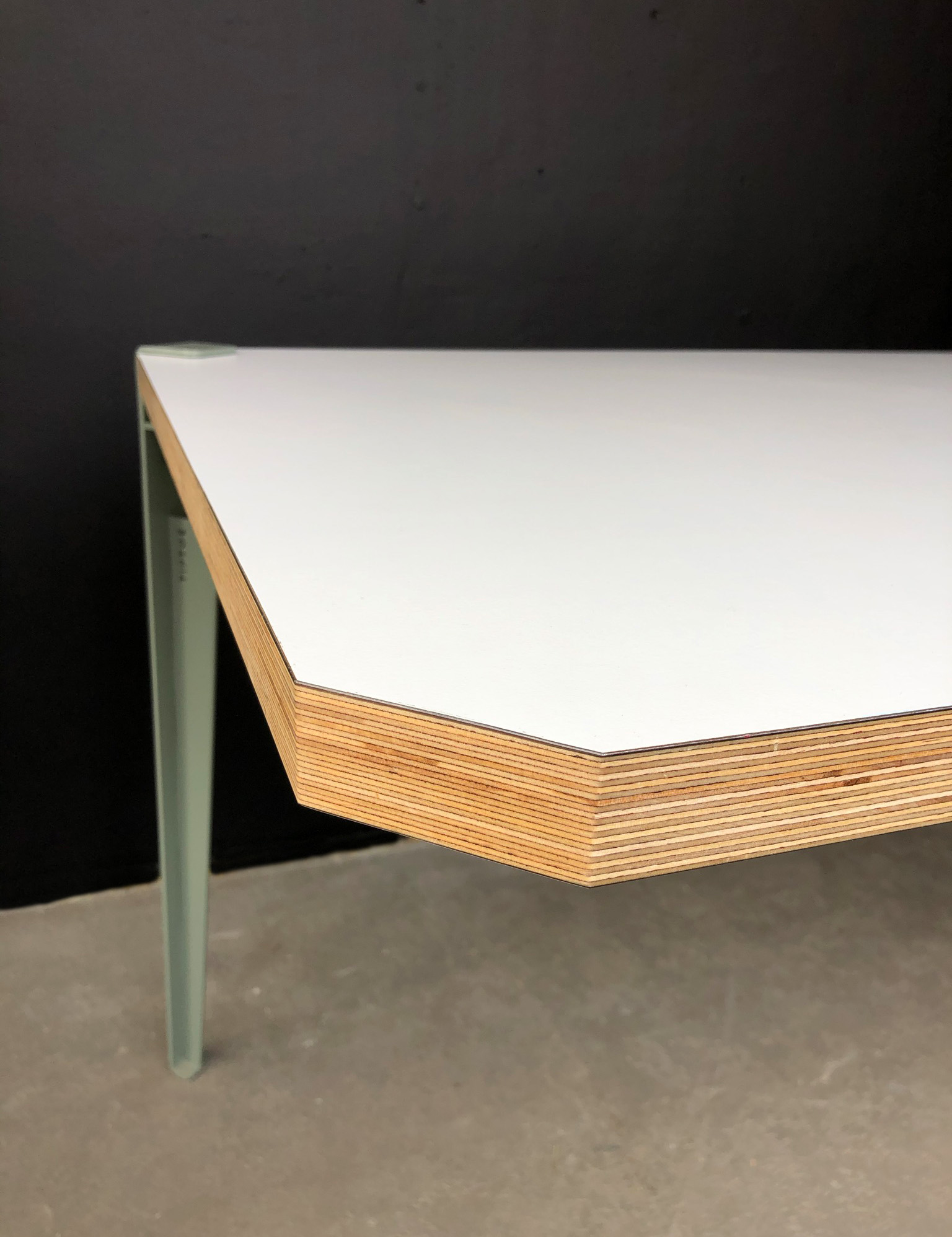Couchtisch mit weißem Laminat, sperrigen Kanten und pastelgrünen Metallbeinen