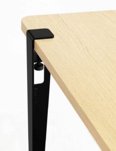 Minimalistische Schwarzmetall-Tischkante mit integriertem Behältnis auf cremefarbenem Holz