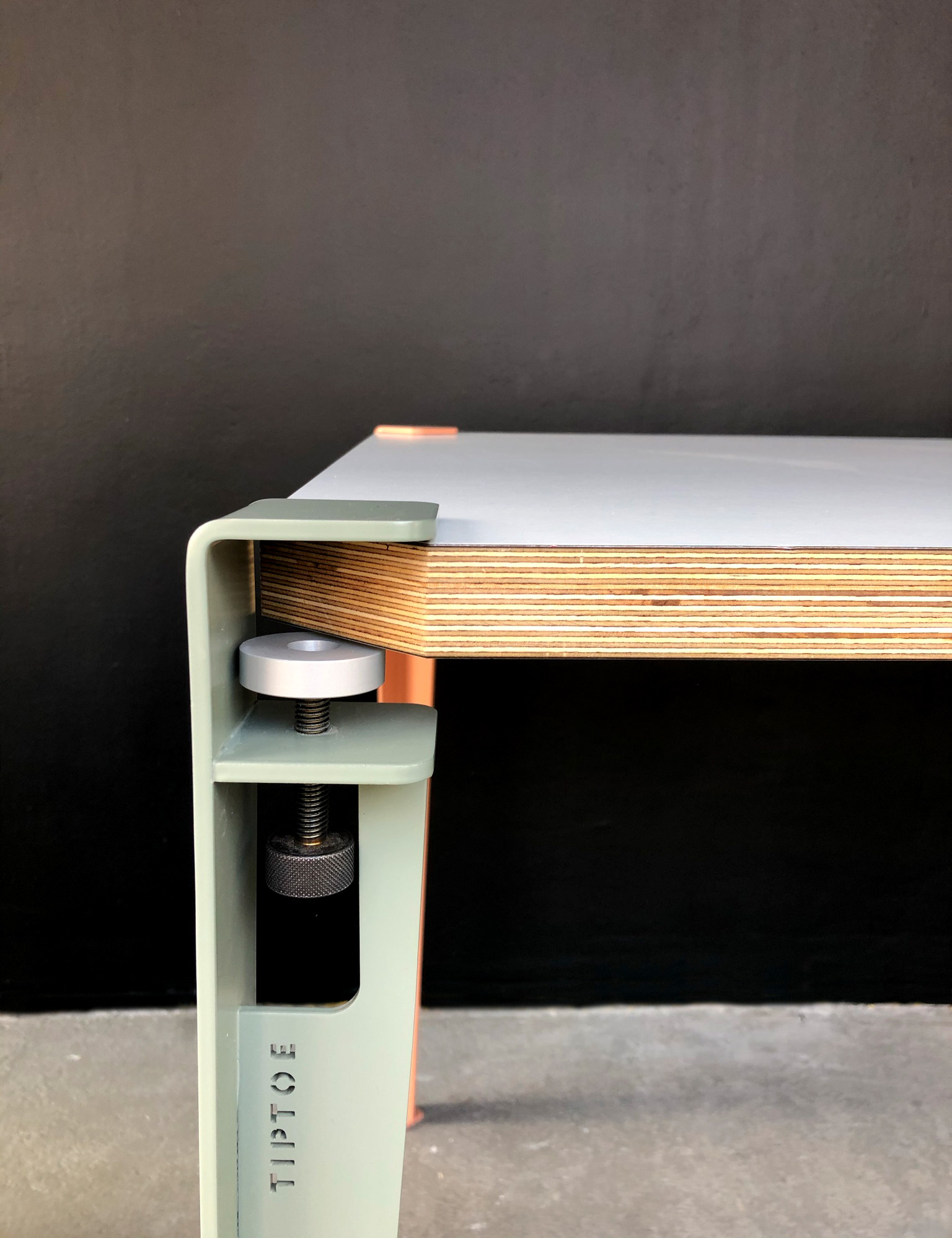 Tisch mit abgeschraegten Kanten und grünem Tischbein von lokalmögntem Designer