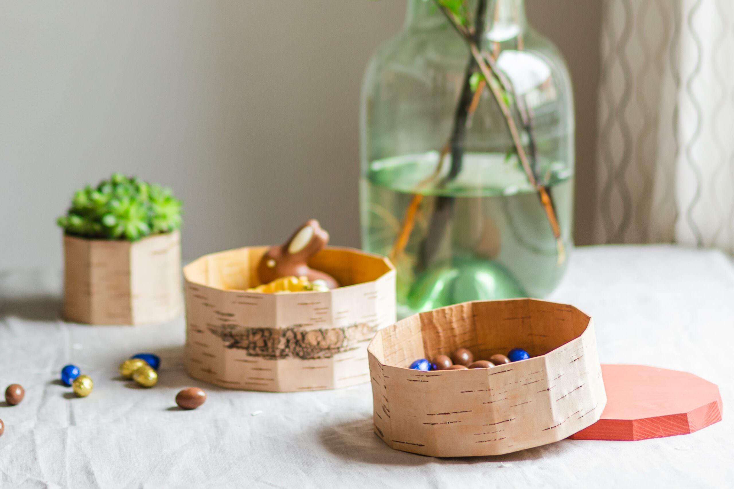 Tisch mit Holzschüsseln, Nüssen und Blumen in einem designlichen Raum