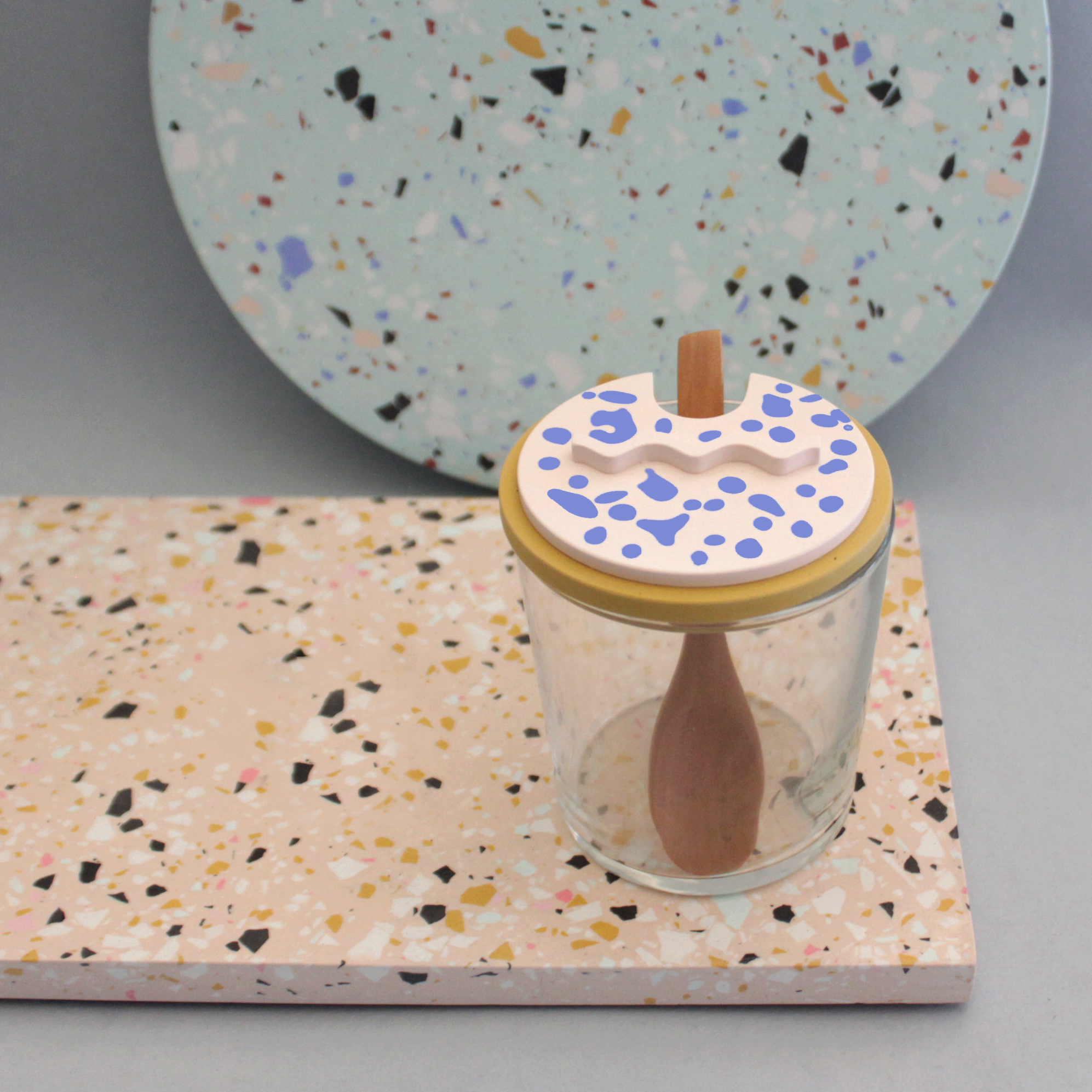 Glasdose mit keramischem Deckel auf Terrazzo-Platte