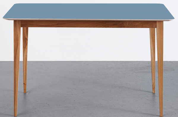 Moderner Esstisch mit blaugrauer Tischplatte und elegantem Holzgestell auf grauem Hintergrund