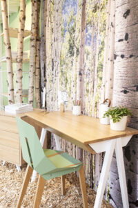Holzarbeitsplatz mit grünem Stuhl Pflanze und Vase für nachhaltiges Interiordesign