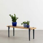 Holztablette mit blauen Vasen und Pflanzen in Ecke des Zimmers