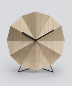 Moderna Tischuhr aus hellem Holz mit schlanken metallenen Beinen und minimalistischen Zeigern
