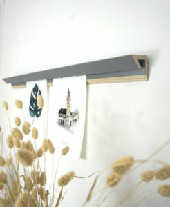 Holzregal mit Bild und Dekoration auf grauer Wand