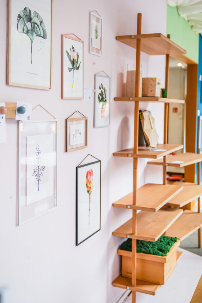 Schaufenster mit Kunstwerken und Pflanzen, erzeugt ein gemütliches Ambiente
