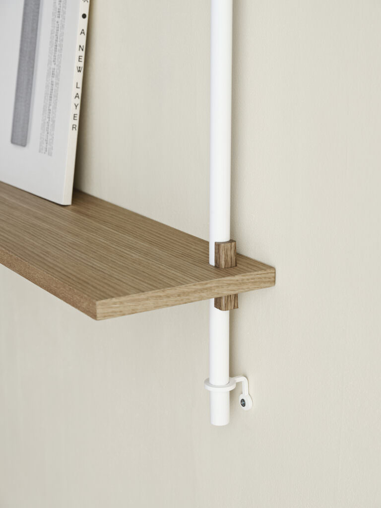 Holzregalwand mit weißen Rohren und Büchern an weißer Wand im Stil von Lokaldesign