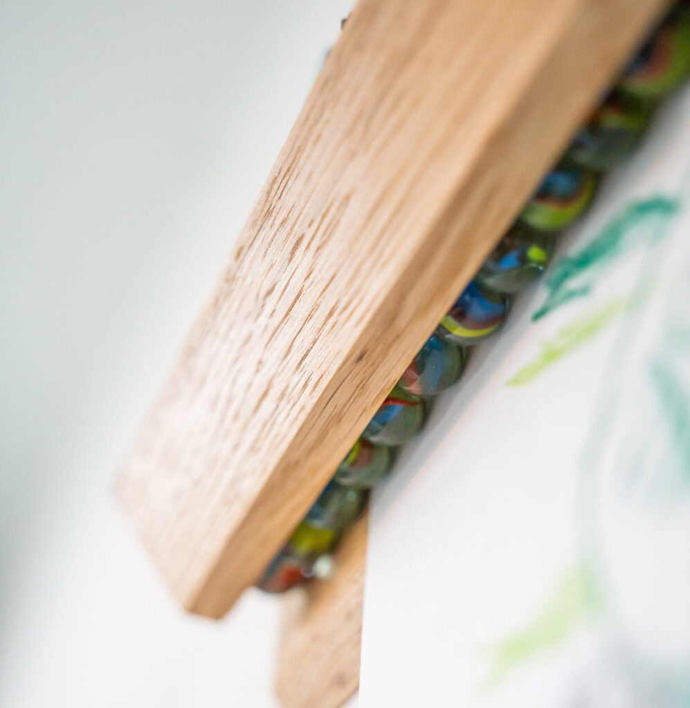 Wooden frame with colorful glass bead necklace in a cozy room