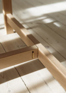 Detailsatz eines goldenen Knopfs auf einem Holzstuhl in der Konstruktion von Esstischen