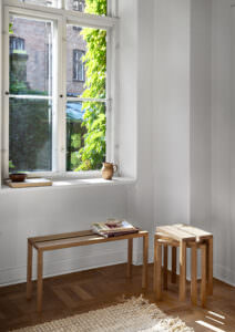 Minimалиstischer Esszimmerraum mit eichenen Tischen und handgefertigten Accessoires