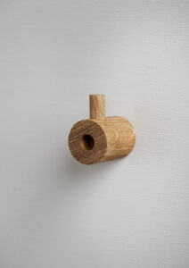 Hängendes Holzmutterschlüsselregal aus Eiche an weißer Wand im skandinavischen Interieurstil