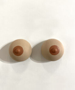 Zwei Brustmagnete auf weißer Oberfläche