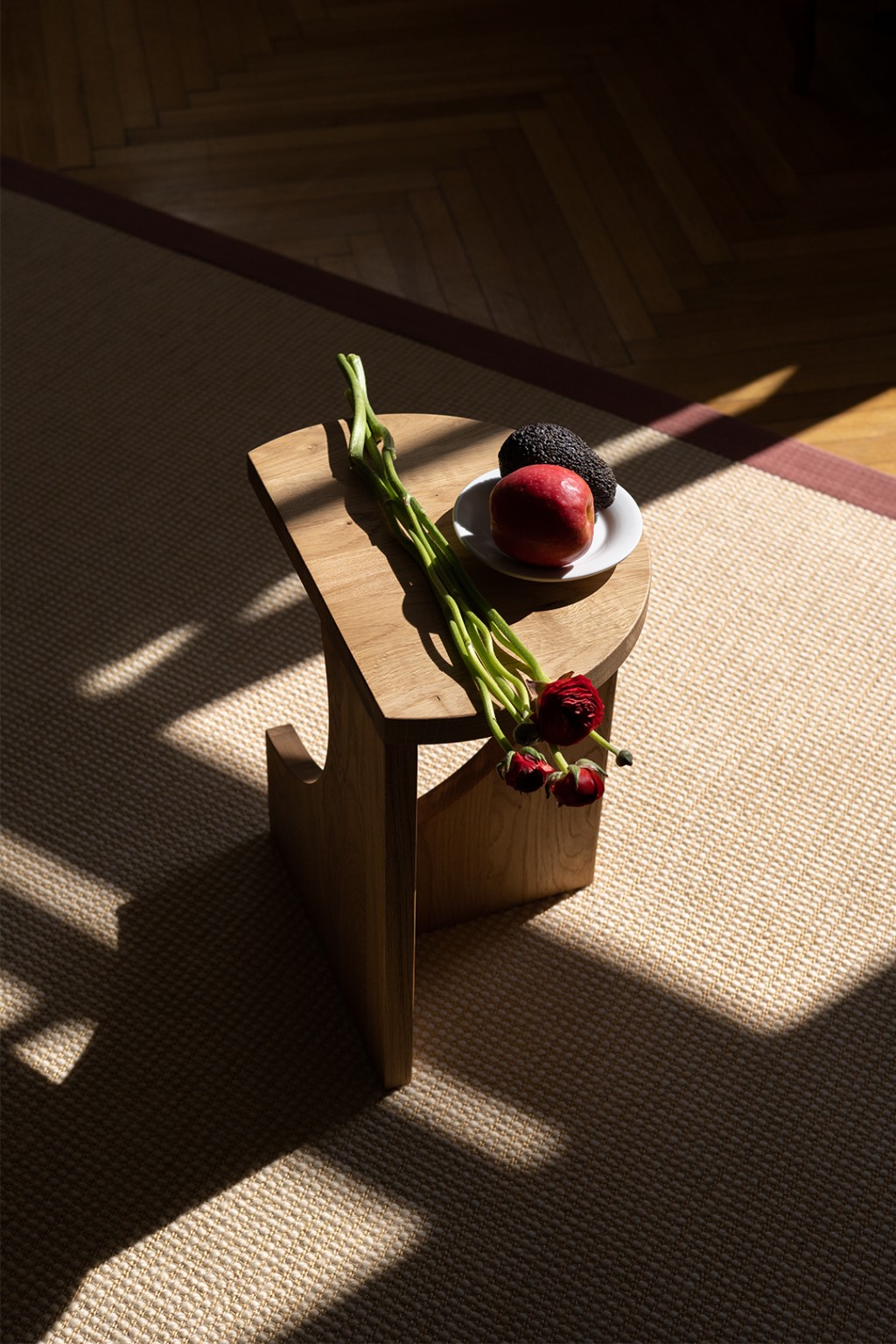 Graue Holz-Tischplatte mit Apfel und Rosen, nachhaltiges Designmöbel-Detail für stilvolles Interior und Wohnaccessoires
