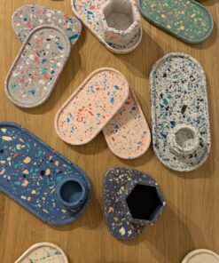 Bunte Terrazzo-Schalen und Behälter auf schwebender Plattform, kreative Wohnaccessoires für nachhaltiges Interior-Design