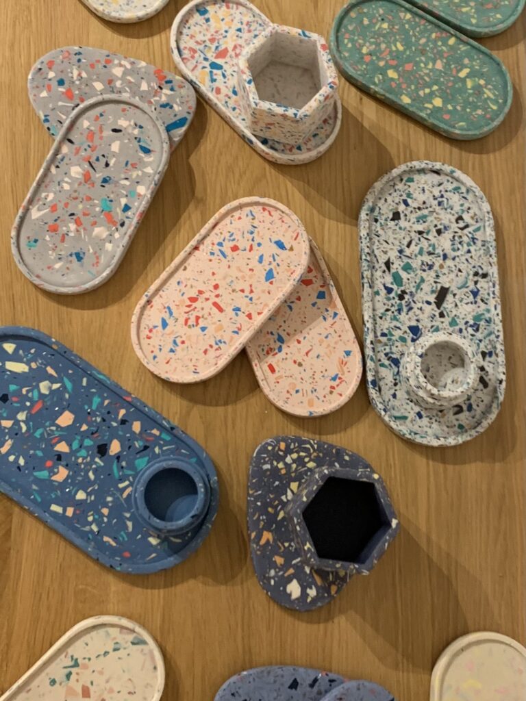 Bunte Terrazzo-Schalen und Behälter auf schwebender Plattform, kreative Wohnaccessoires für nachhaltiges Interior-Design