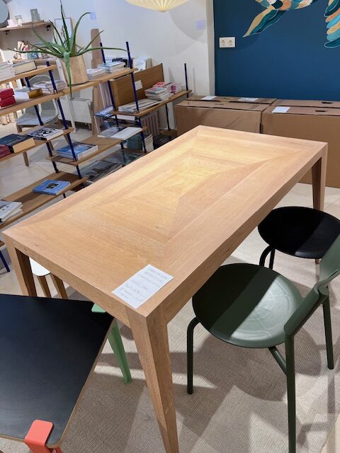 Triangular wooden Designmöbel-Tisch mit bunten Stühlen, harmonische Einrichtung, nachhaltiges Design, Interior in Hamburg