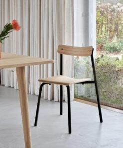 Schwarzer Etude Designstuhl von tiptoe im minimalistischen Interior, dazu weißer Holztisch und Blumen, nachhaltiges Design