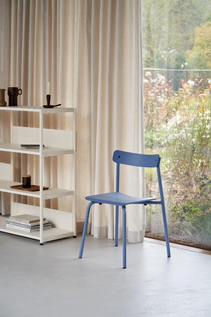 Blauer Etude Designmöbel von tiptoe im hellen Wohninterior, umgeben von Bücherregal und Vase – nachhaltiges Design
