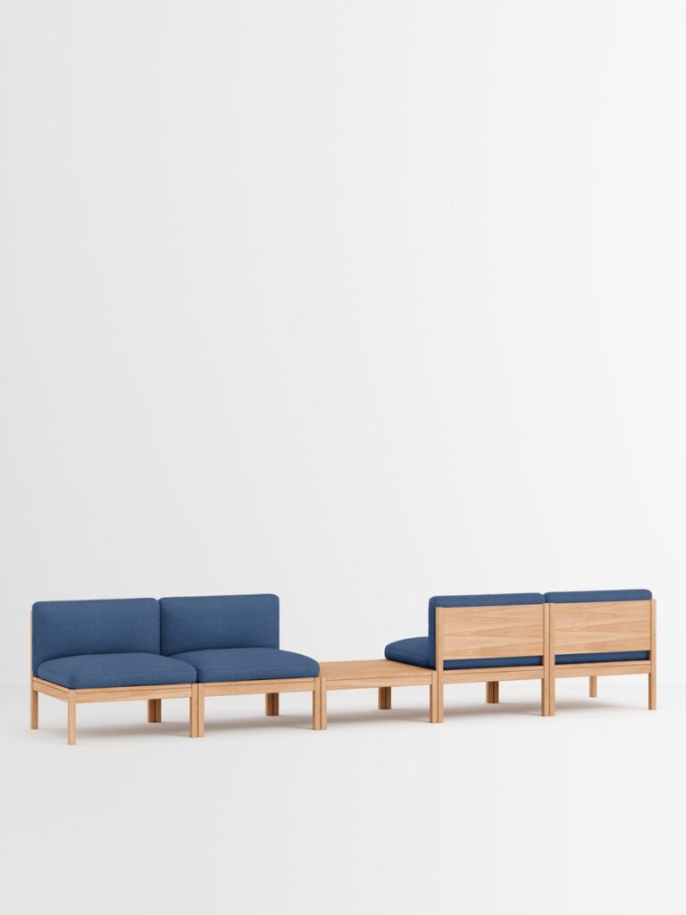 Modernes blaues Designmöbel‑Sofa mit Holz‑Tisch im minimalistischen Interior, nachhaltige Einrichtung aus Hamburg