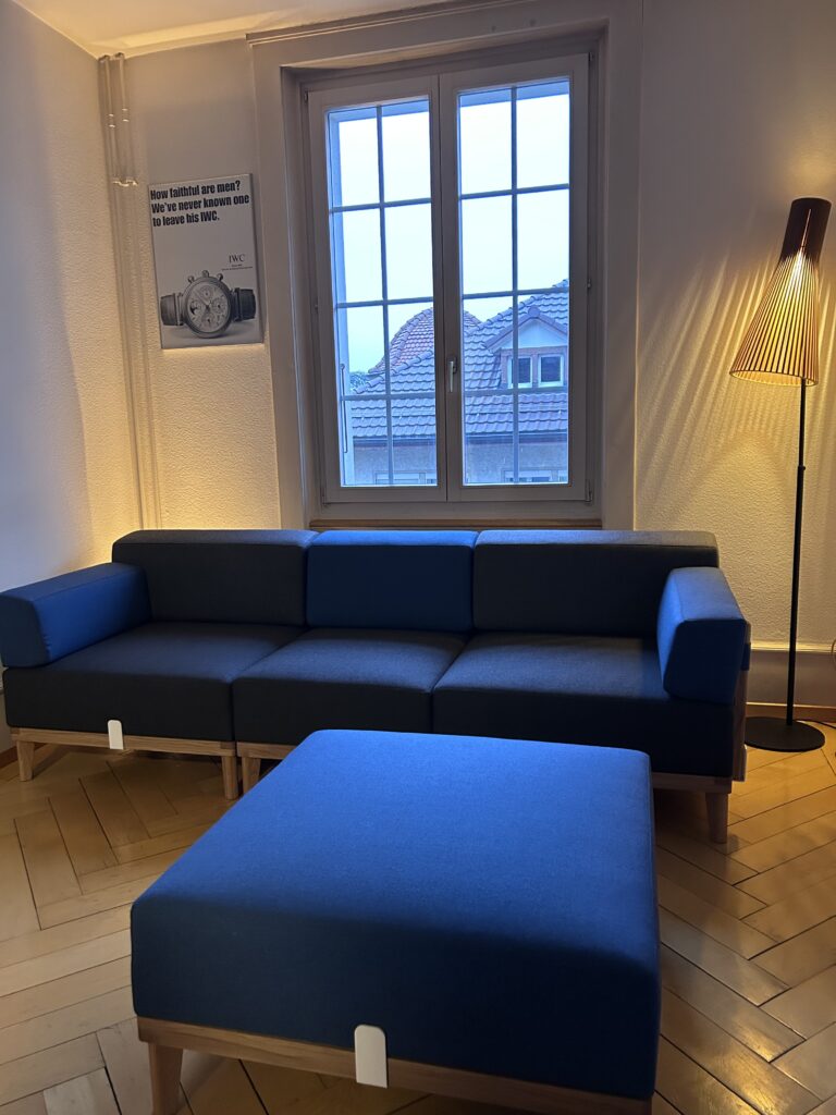 Modulares Sofa in Dunkelblau mit Ottomane und Stehleuchte als nachhaltiges Designmöbel für modernes Interior in Hamburg