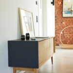 Schwarze Drahtkonstruktion mit hellem Holzgestell als Designmöbel-Kasse, gefüllt mit Kugeln, modernes nachhaltiges Interior