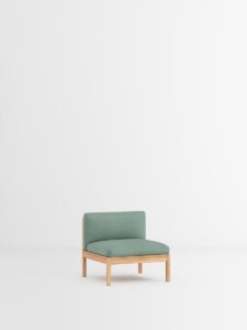 Grüner Designmöbel-Sessel mit Holzrahmen in weißem Minimal-Interior, nachhaltiges Design aus Hamburg